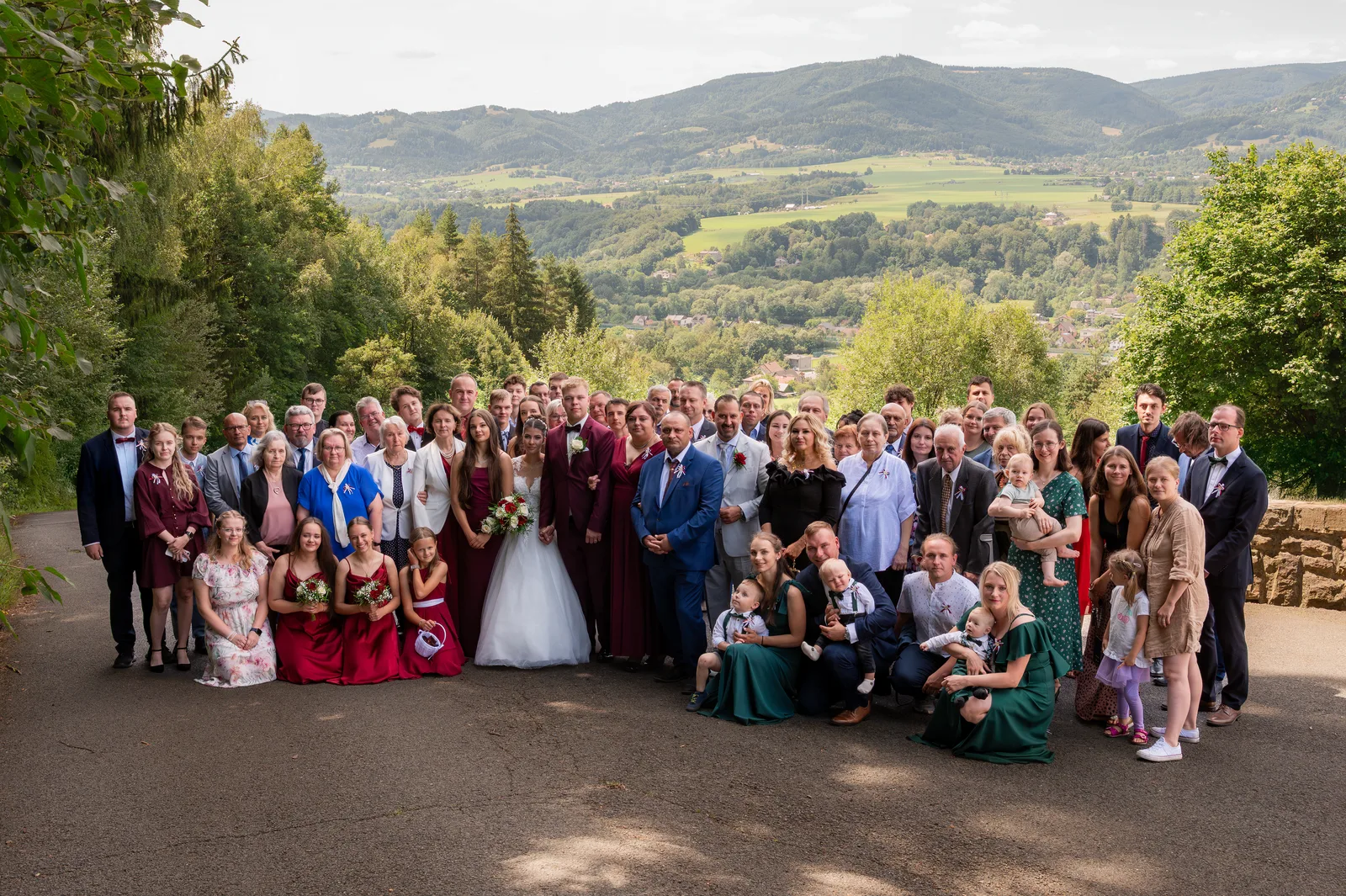 Společná fotografie svatebčanů na vyhlídce nad krajinou